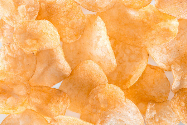 full frame view of unhealthy potato chips background on white 