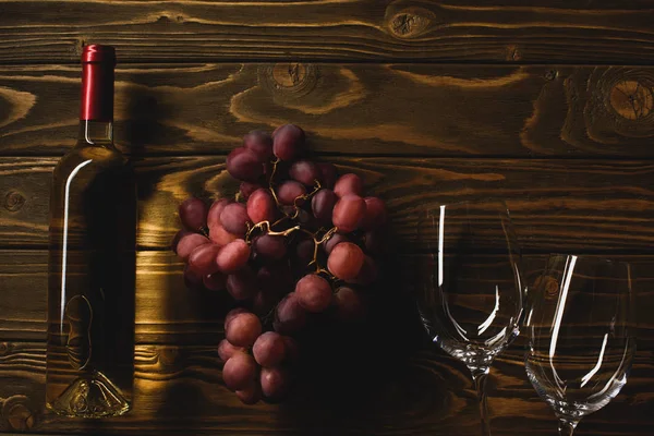 木製のテーブルにブドウとメガネと白ワインのボトルのトップ ビュー — ストック写真