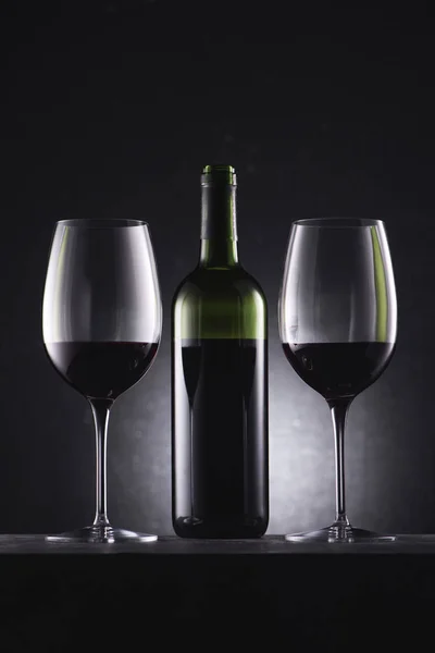 Ποτήρια Γεμίζουν Κόκκινο Κρασί Και Κρασί Μπουκάλι Στη Μέση Μαύρο — Φωτογραφία Αρχείου