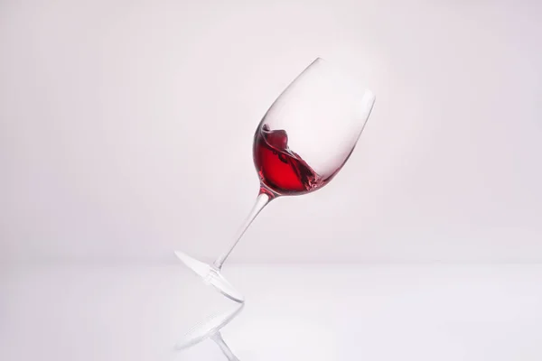 Наклонный Стакан Красным Вином Отражающей Поверхности Белом — стоковое фото