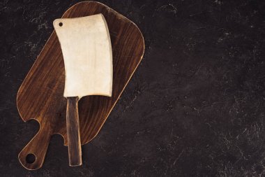 top view of butcher axe on wooden cutting board on marble table clipart