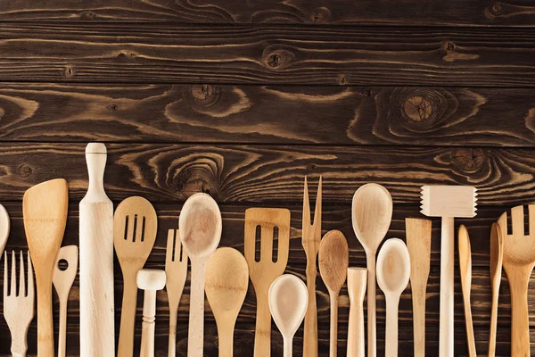 top view of kitchen utensils placed in row on wooden table