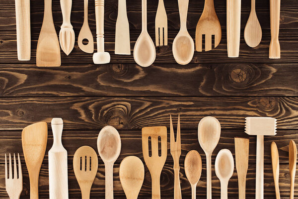 top view of kitchen utensils placed in rows on wooden table