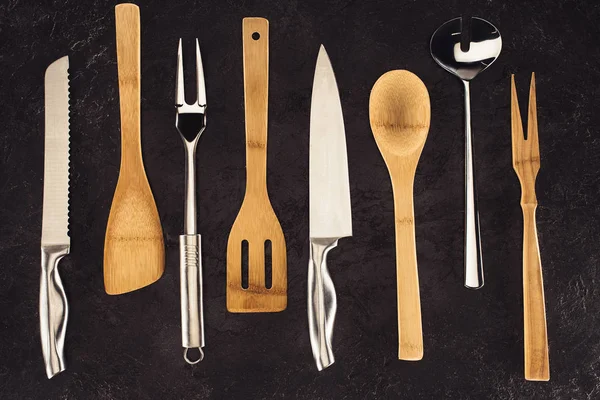 Top view of kitchen utensils placed in row on black marble table — Stock Image Top View Kitchen Utensils Placed Row Black Marble Table Stock Photo