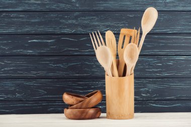 closeup view of ramekins and kitchen utensils in front of wooden wall clipart