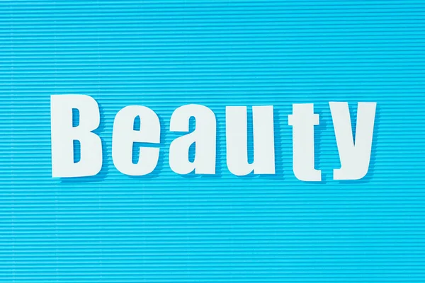 Weißes Wort Schönheit Auf Hellblau Gestreiftem Hintergrund Schönheitskonzept — Stockfoto