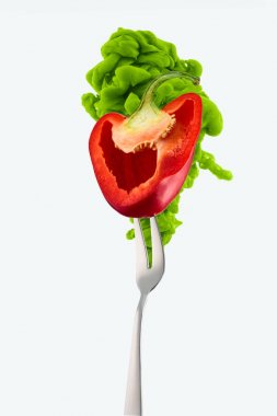 half of red bell pepper on fork and green ink isolated on white clipart