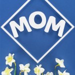 Top view of daffodils and word mom in frame isolated on blue, mothers day concept