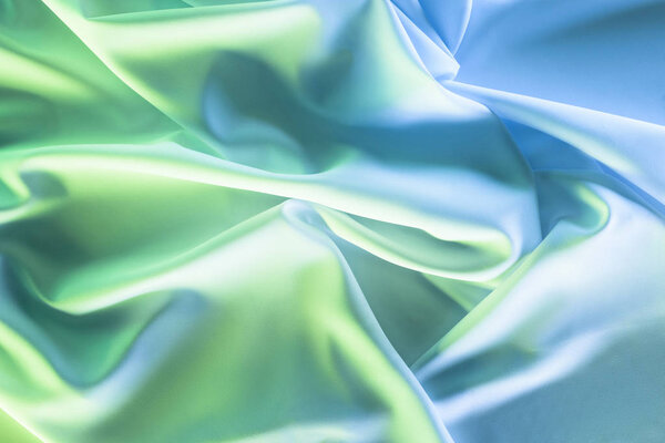 toned picture of green and blue soft silk cloth as backdrop