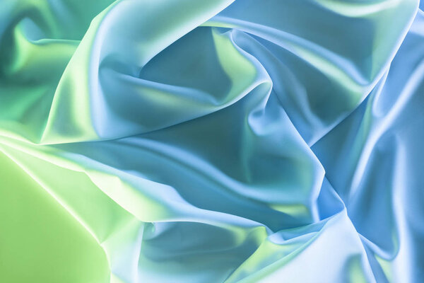 toned picture of green and blue soft silk cloth as backdrop