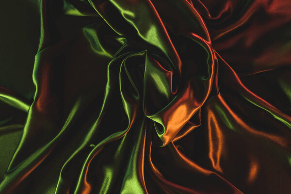 close up view of dark green crumpled silk cloth as backdrop