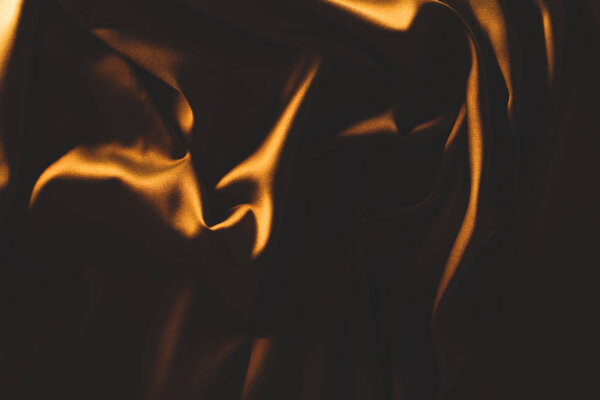 close up view of dark crumpled silk cloth as backdrop