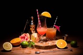 leckere Alkoholcocktails auf Holzbrett mit Früchten auf dem Tisch