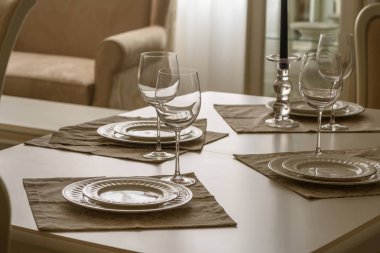 Set of dinner tableware on table in dining room clipart