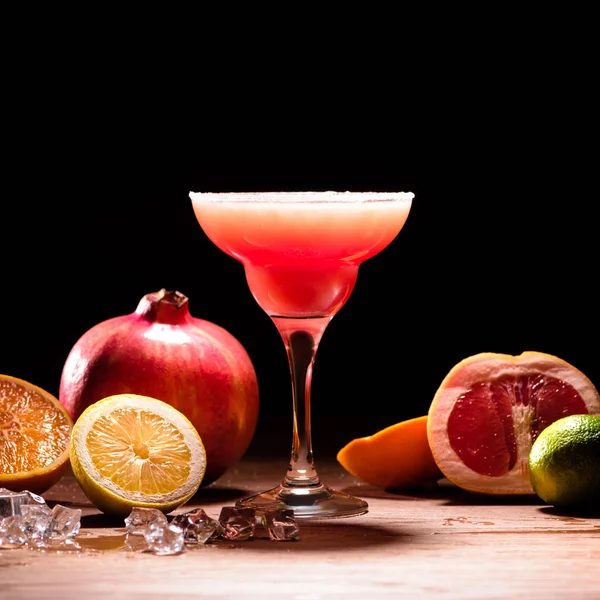 木製のテーブルに熟した果実が入った赤いアルコール飲料 — ストック写真