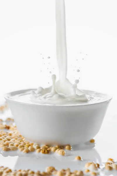 Mléko Stříkající Bílé Míse Sójové Boby Bílém Pozadí — Stock fotografie