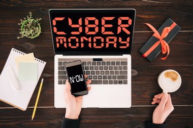 Bussinesswoman smartphone, kahve fincanı, laptop ve hediye kutusu, şimdi yazıtlar ve cyber Pazartesi ile kırpılmış görüntü