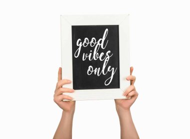 Cropped view of woman holding chalkboard with inscription good vibes only isolated on white clipart