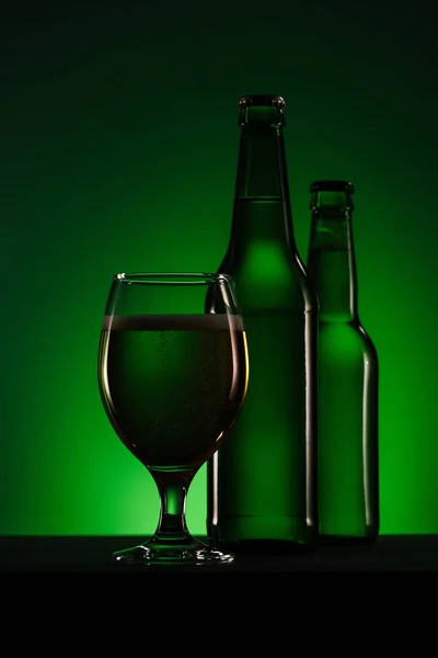 Vista Cerca Botellas Vaso Cerveza Sobre Fondo Verde Oscuro —  Fotos de Stock