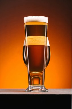 close up view of arrangement of glasses of beer on orange backdrop clipart