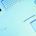 Blautöniges Bild von Büroklammern, digitalem Tablet, leerem Lehrbuch, Stift, Computertastatur und Maus