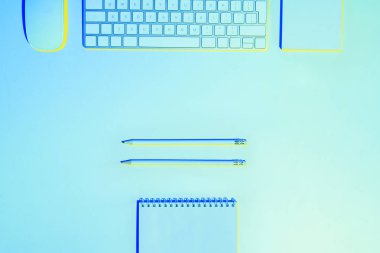 bilgisayar klavye ve fare, kalemler ve boş ders kitabı mavi tonda resmi 