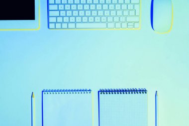 boş ders kitapları, kurşun kalem, dijital tablet, bilgisayar fare ve klavye mavi tonda resmi 