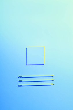blue toned picture of sticky note and three pencils placed in row  clipart