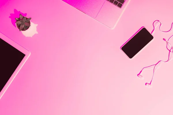 デジタル タブレット ラップトップ スマート フォン テーブルの上のイヤホンのピンクのトーンの画像  — 無料ストックフォト