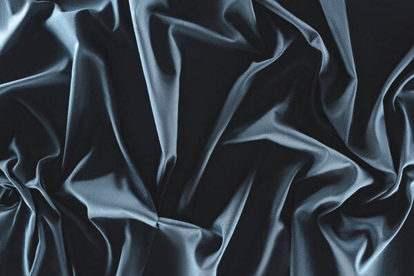 close up view of crumpled dark blue silk fabric as background