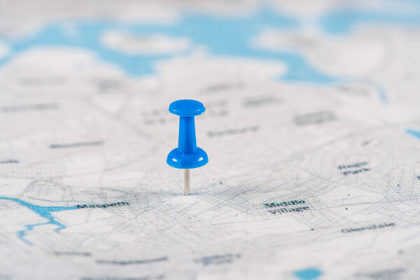 close-up shot of blue pin on travel map