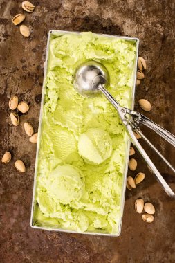 top view of pistachio ice cream with ice cream scoops on table clipart