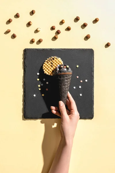 Körülvágott Kép Gazdaság Black Ice Cream Sárga — Stock Fotó