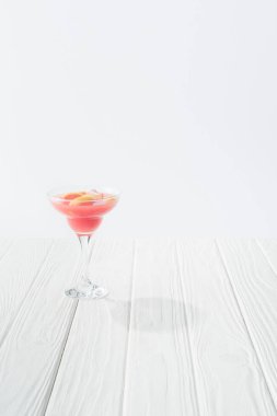 close up view of tasty summer alcohol cocktail on white wooden tabletop on grey background clipart