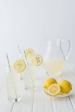 limonata sürahi ve gözlük payet ile görünümü gri arka plan üzerinde beyaz ahşap masa üzerinde kadar kapatın