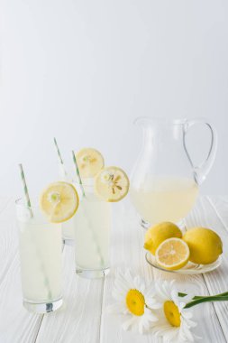 limonata sürahi ve gözlük payet ile görünümü gri arka plan üzerinde beyaz ahşap masa üzerinde kadar kapatın