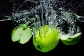 pohled čerstvých zelených jablek ve vodě izolována na černém pozadí na plochu