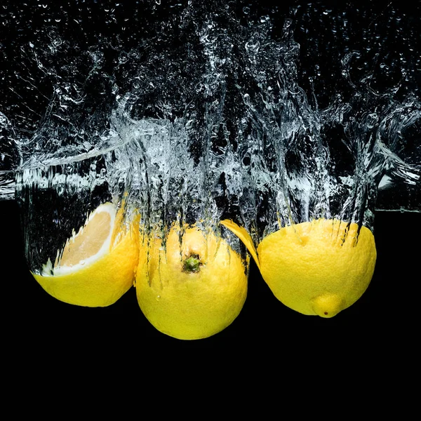 黒で隔離飛散とクローズ アップ水に新鮮なレモンの表示 — ストック写真
