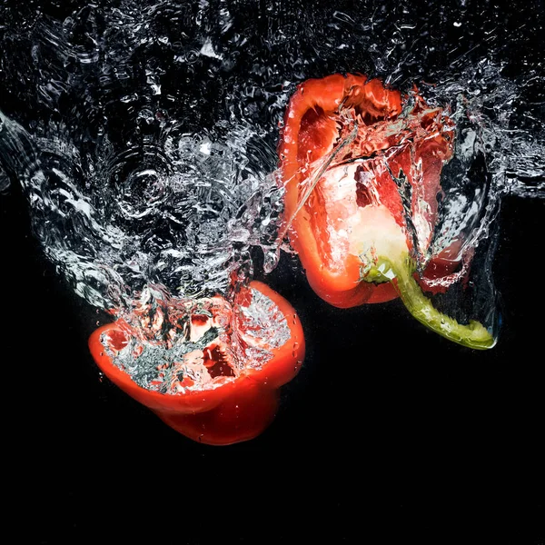 Nahaufnahme Von Paprika Stücken Wasser Isoliert Auf Schwarz — kostenloses Stockfoto