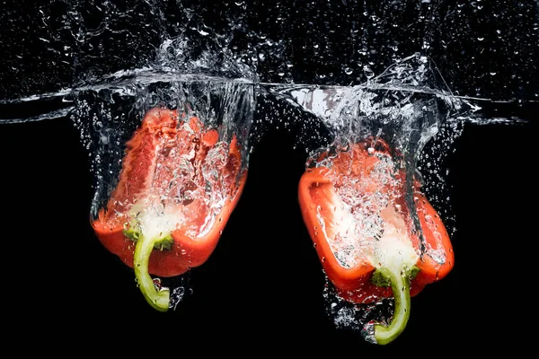 Nahaufnahme Von Paprika Stücken Wasser Isoliert Auf Schwarz — kostenloses Stockfoto