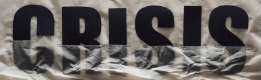 panoramic shot of black word crisis sinking in paper symbolizing water on grey paper background clipart