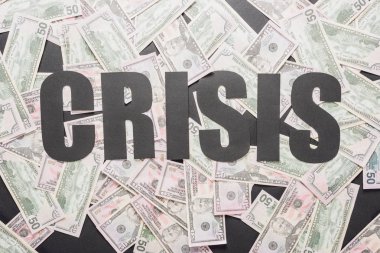 Siyah yüzeye saçılmış dolar banknotları üzerinde kara kelime krizinin en üst görüntüsü