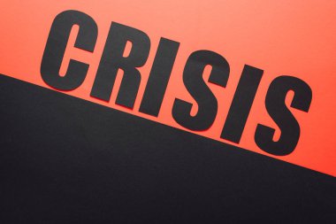 top view of word crisis on black and red background divided by sloping line  clipart