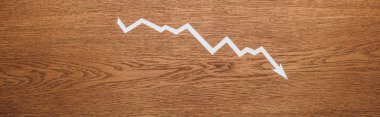 top view of white paper cut recession arrow on wooden desk, panoramic shot clipart