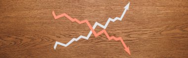 top view of paper cut increase and recession arrows on wooden desk, panoramic shot clipart