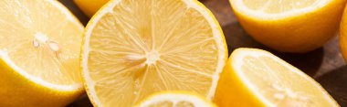 close up view of ripe cut lemons on wooden cutting board, panoramic shot clipart