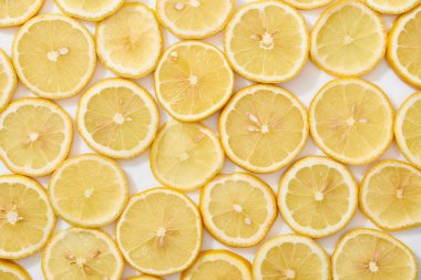 Olgun taze sarı limon dilimlerinin beyaz arkaplandaki üst görünümü