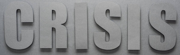 top view of word crisis on grey background with shadows, panoramic shot