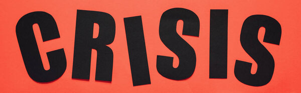 top view of black word crisis on red background, panoramic shot