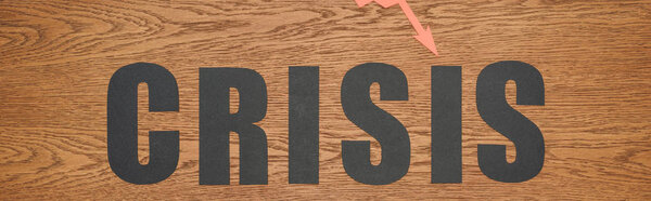 top view of black paper cut word crisis on wooden desk, panoramic shot